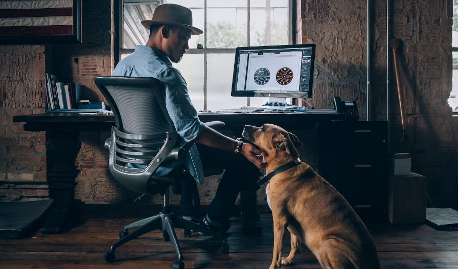 Man sitting on a rolling chair holding dog