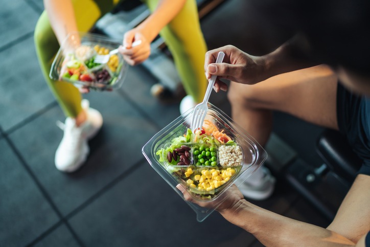 top-view-asian-man-and-woman-healthy-eating-salad-after-exercise-at-fitness-gym