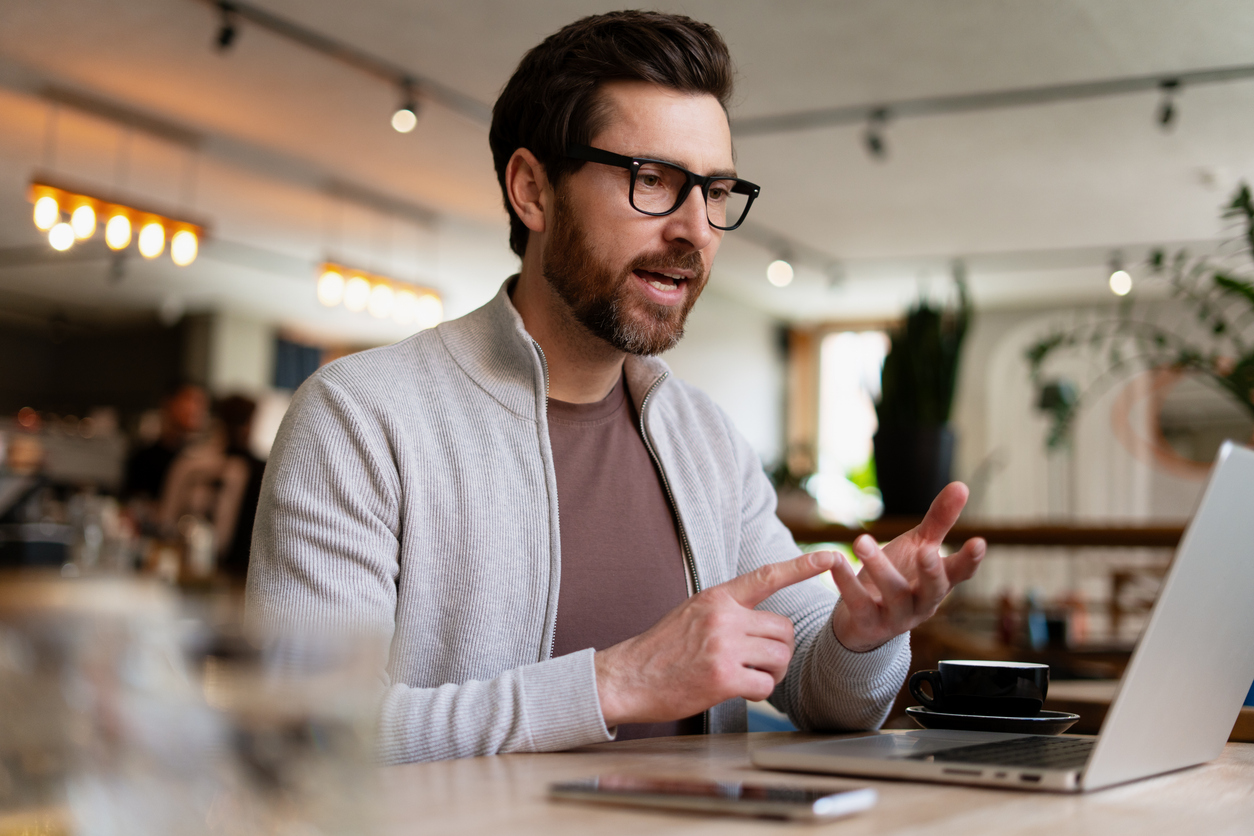 a remote worker having video call using laptop in café