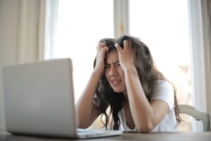 woman working on laptop showing frustration