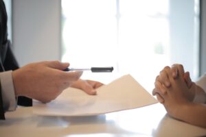 businessman handing client contract to sign