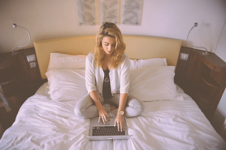 a woman working with her laptop on her bed