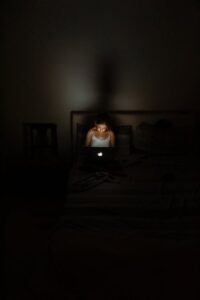 girl working on laptop in dark