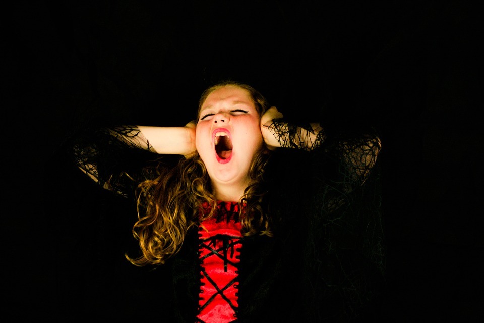 a child screaming covering her ears