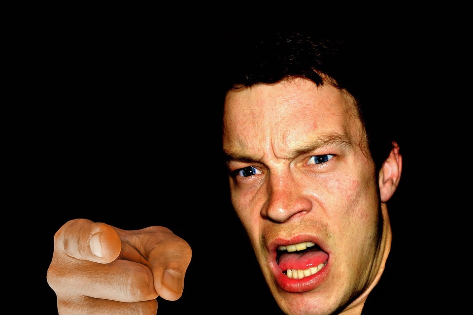 a man with ang angry fac, pointing his index finger