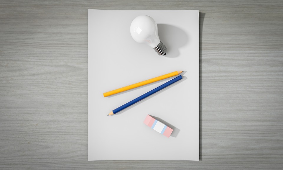 gray surface, empty paper, light bulb, yellow pencil, blue pencil, eraser