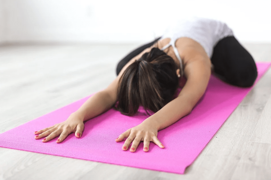 a woman stretching on a yoga mat