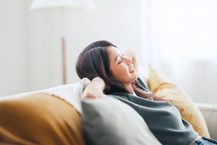 relaxed-young-asian-woman-enjoying-rest-on-comfortable-sofa-at-home-calm-attractive